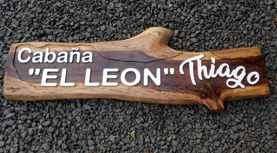 Cartel de madera tallado con el nombre de una cabaña